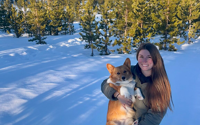 Laken Bose holding a corgi in the snow