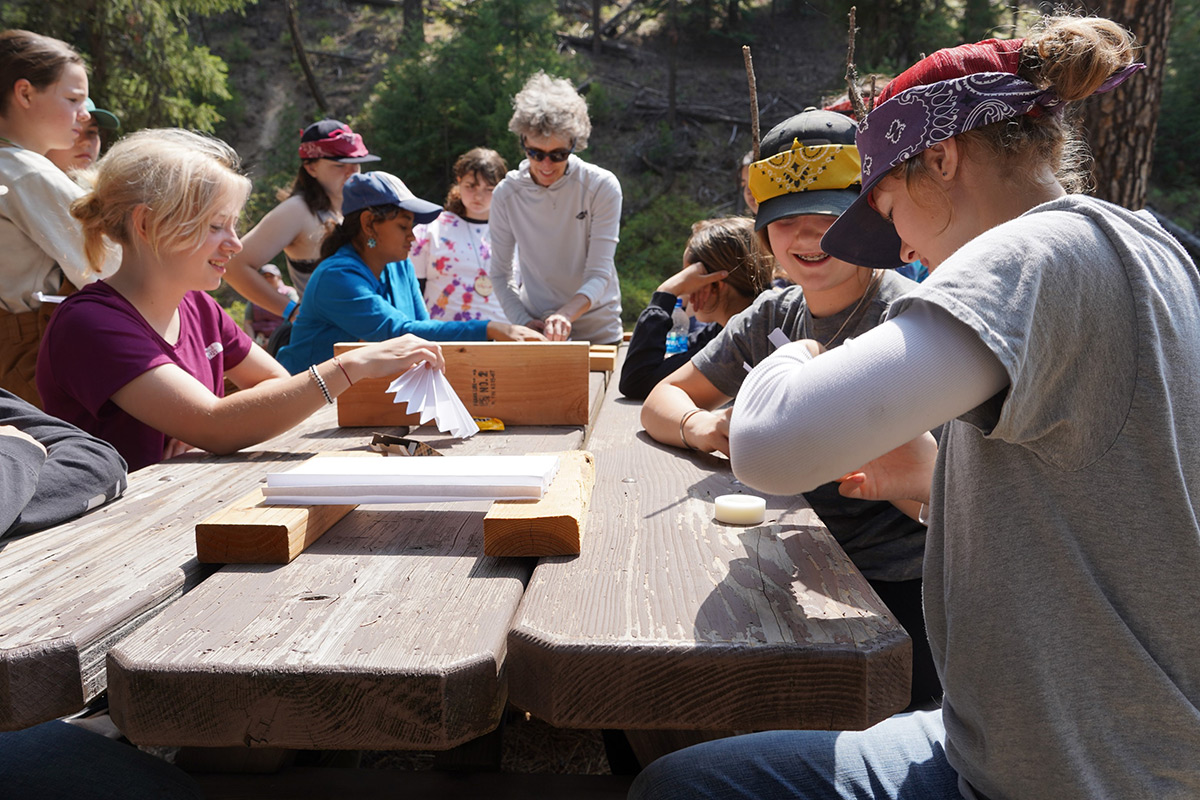 young women sitting around a picnic table